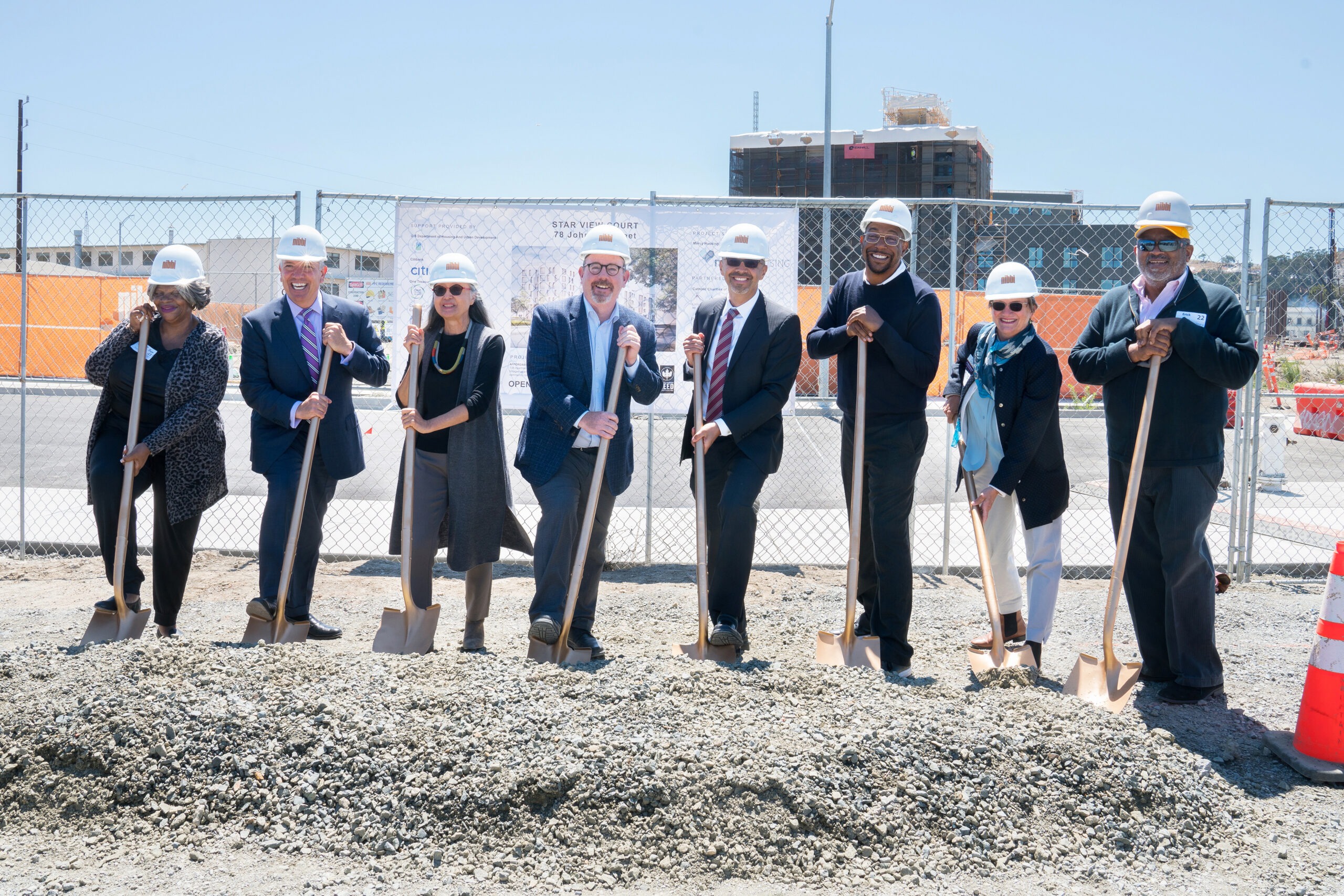 A group of people with hard hats and shovels