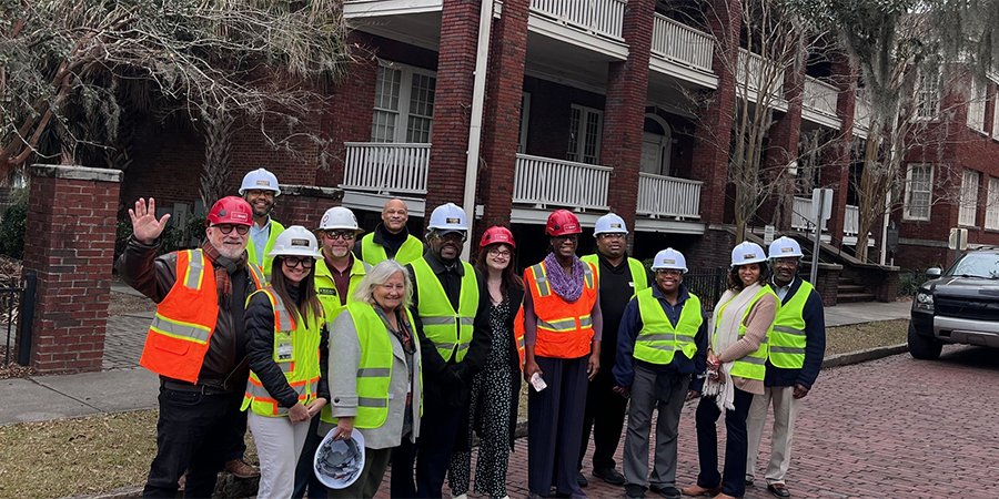 Officials and staff wearing hi-viz vests in front of Heritage Place