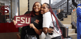 College tour - two smiling college students with a sign