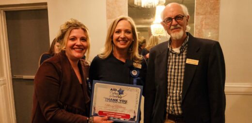 Three people post holding Mercy Housing's Cares Award