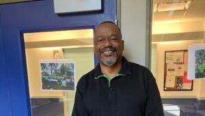 Resident leader Wesley stands in front of the glass door